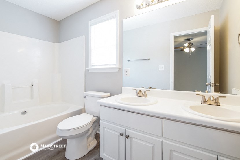 a white bathroom with a toilet and a sink