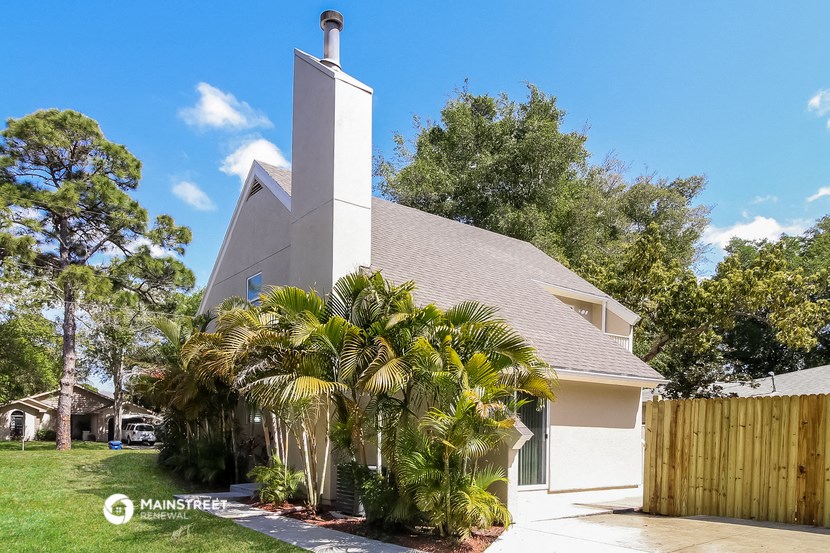 a church with palm trees in front of a house