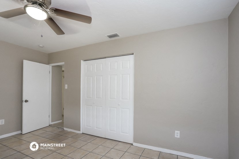 a room with a ceiling fan and a white door