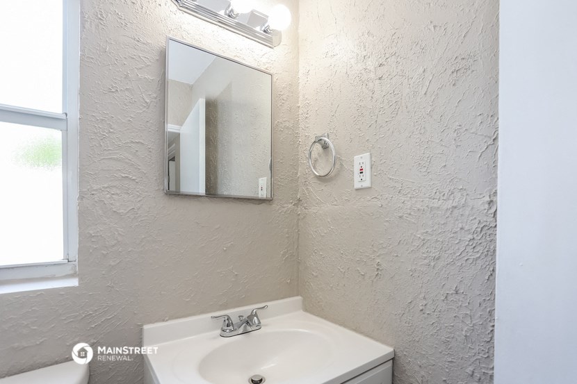 a bathroom with a sink and a mirror and a window