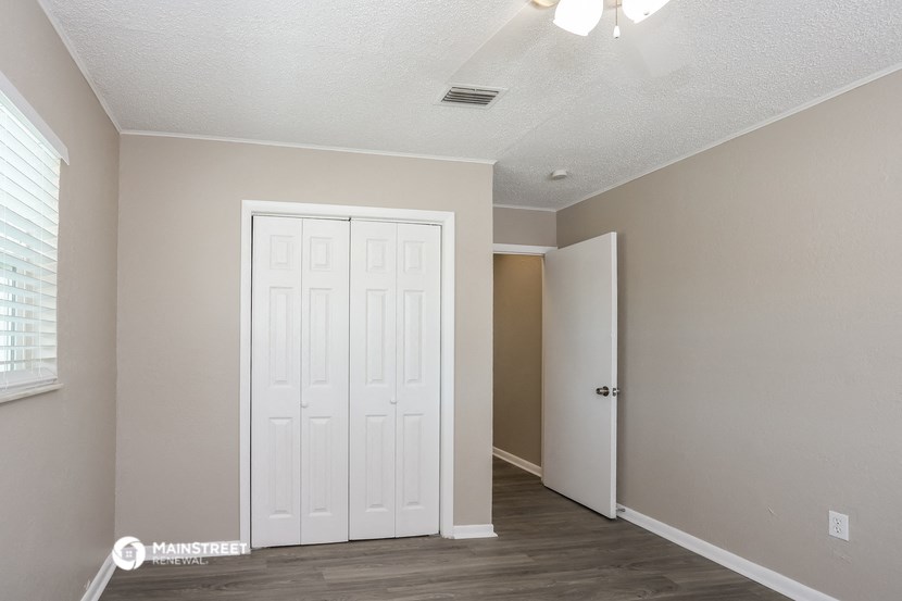 an empty room with a white door and a closet