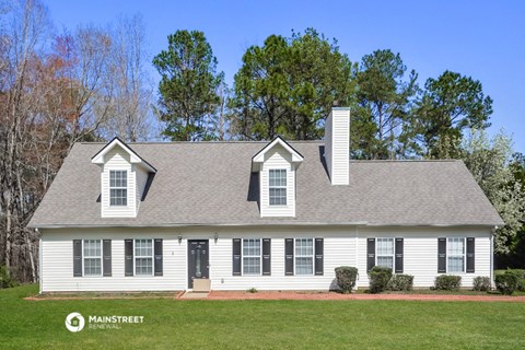 a white house with black shutters and a gray roof