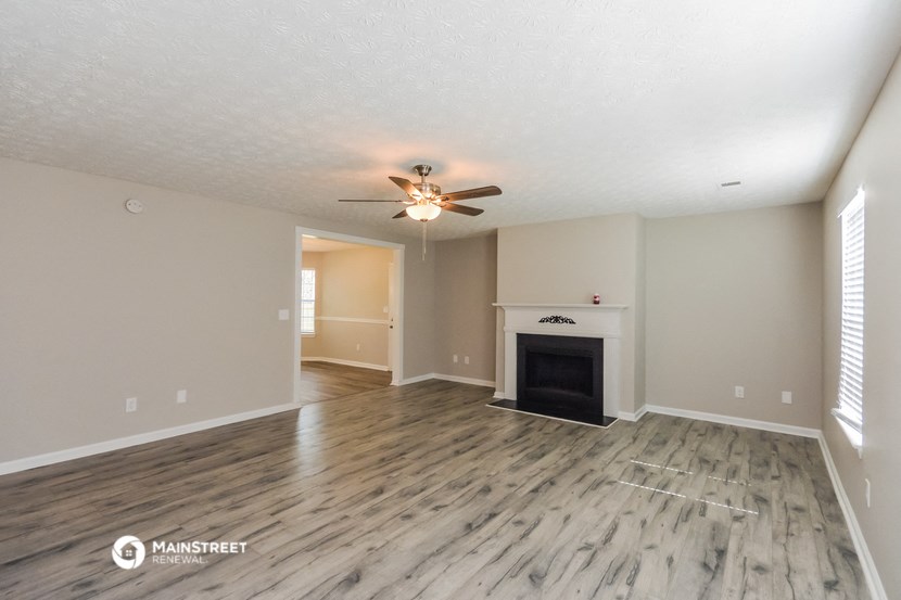 the living room with fireplace and ceiling fan