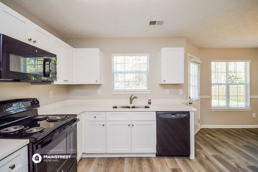 a kitchen with white cabinets and a stove and a sink