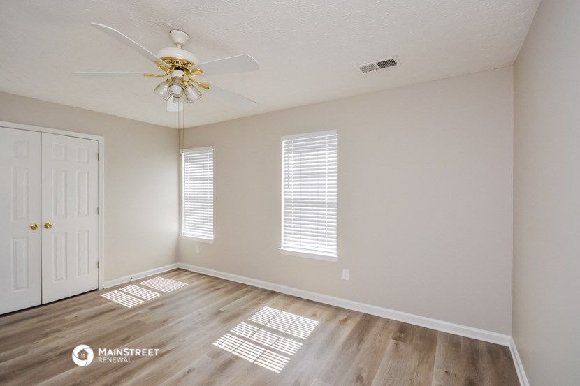 the living room of an empty house with a ceiling fan