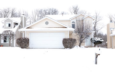 a house in the snow with a white garage door