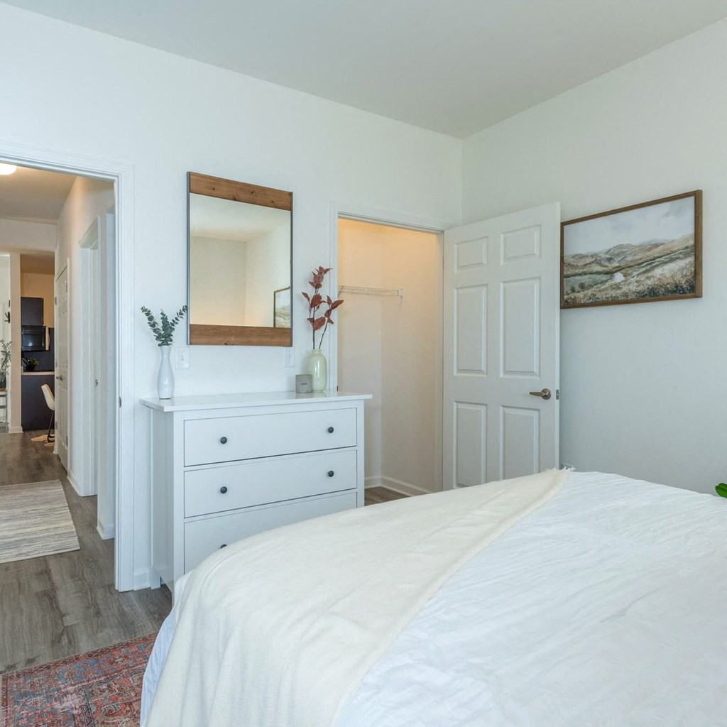 a white bedroom with a white bed and a white dresser