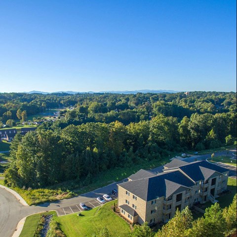 a view of a building from above with a road and trees