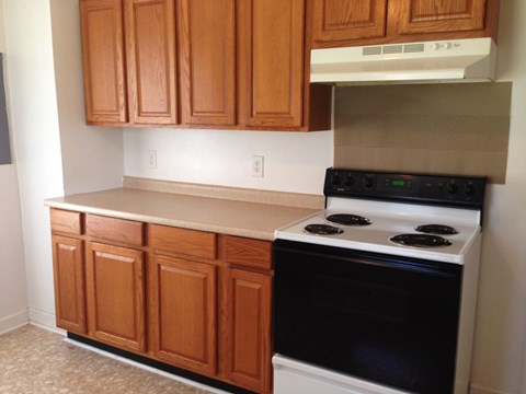 A kitchen with wooden cabinets and a black stove top oven.