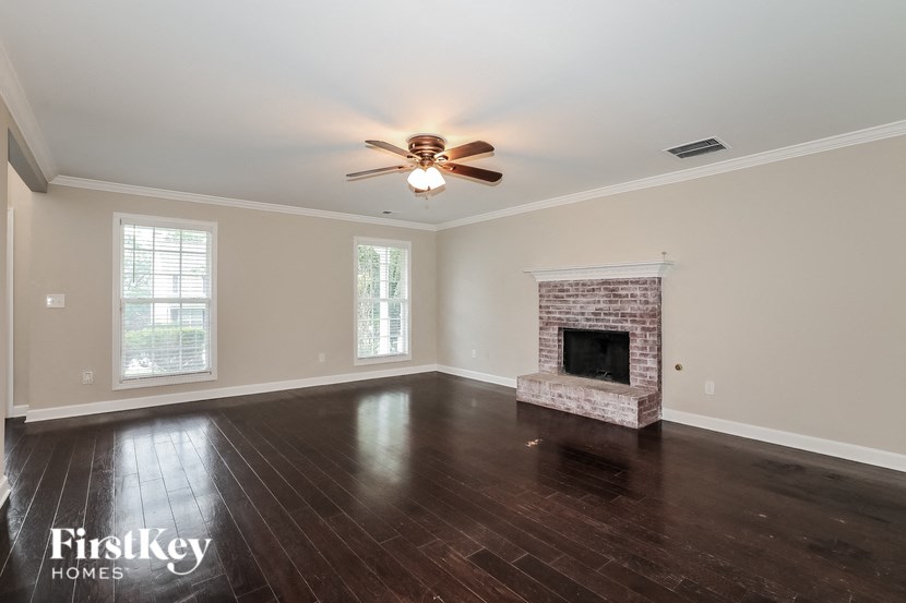 a empty living room with a fireplace and a ceiling fan