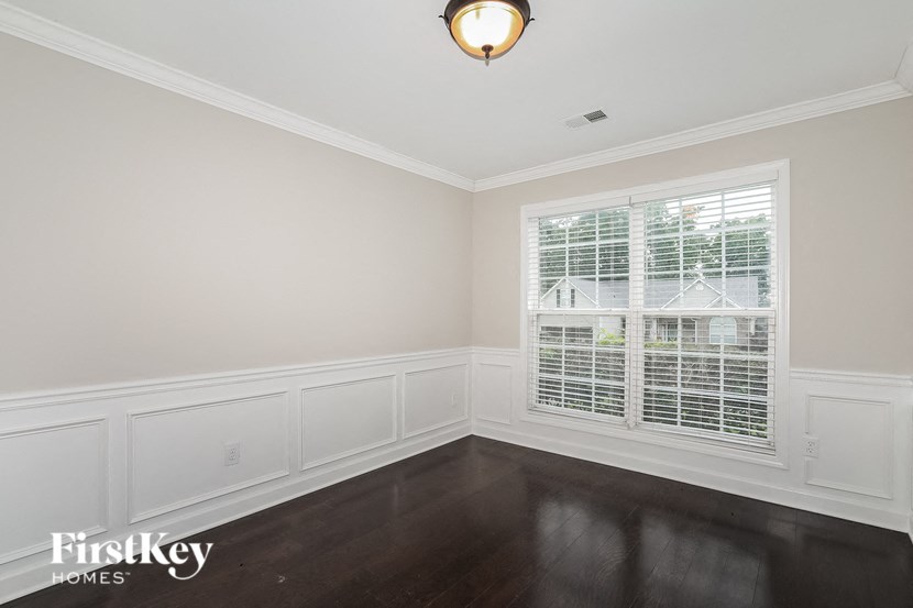 an empty room with a large window and dark wood floors