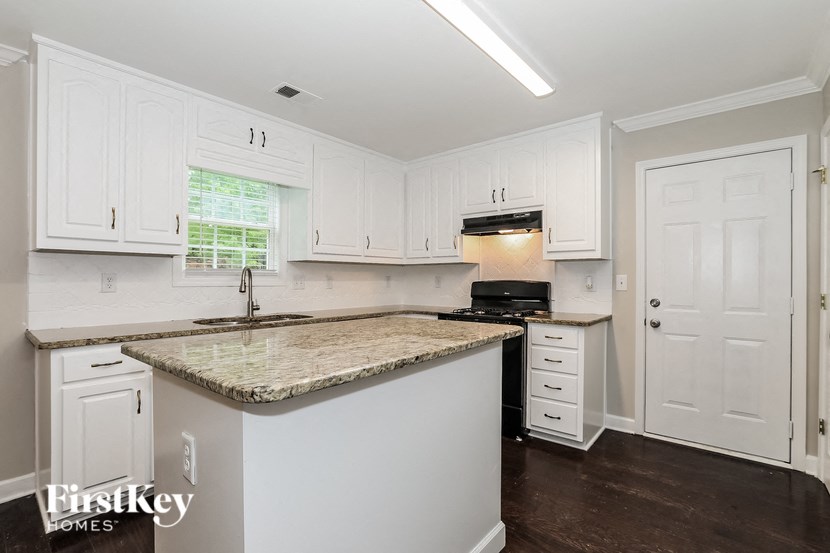 a kitchen with white cabinets and a counter top