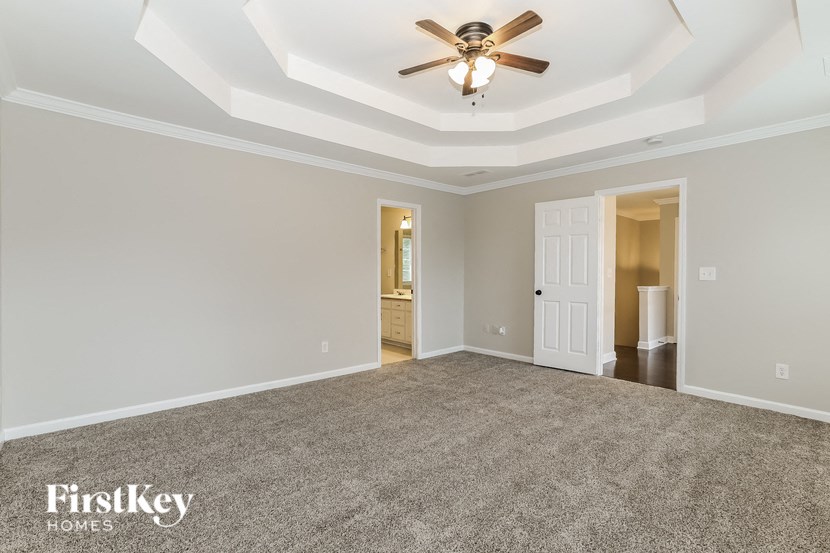 an empty living room with a ceiling fan