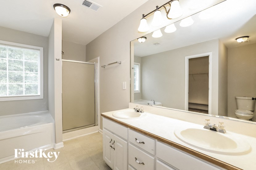 a bathroom with two sinks and a shower and a mirror