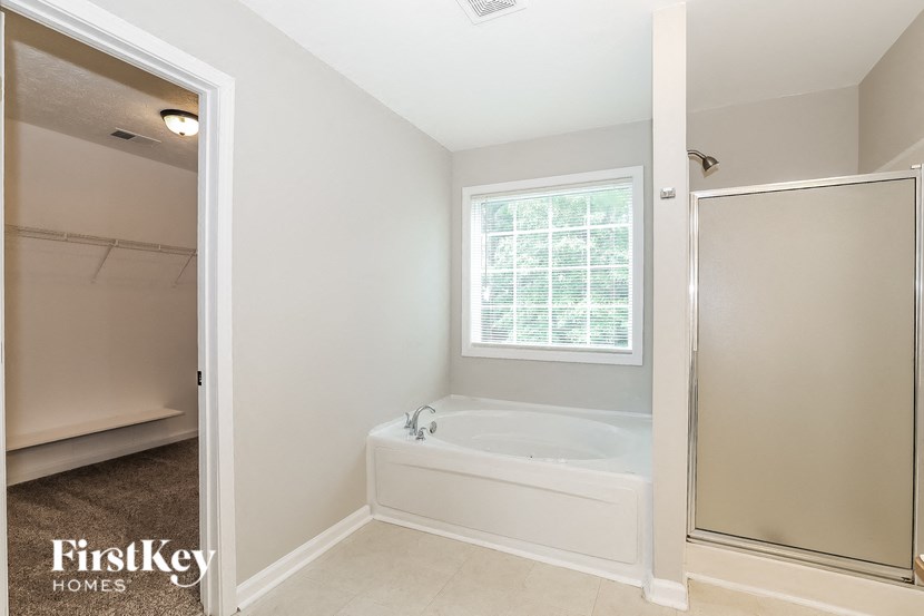 a bathroom with a tub and a shower and a window