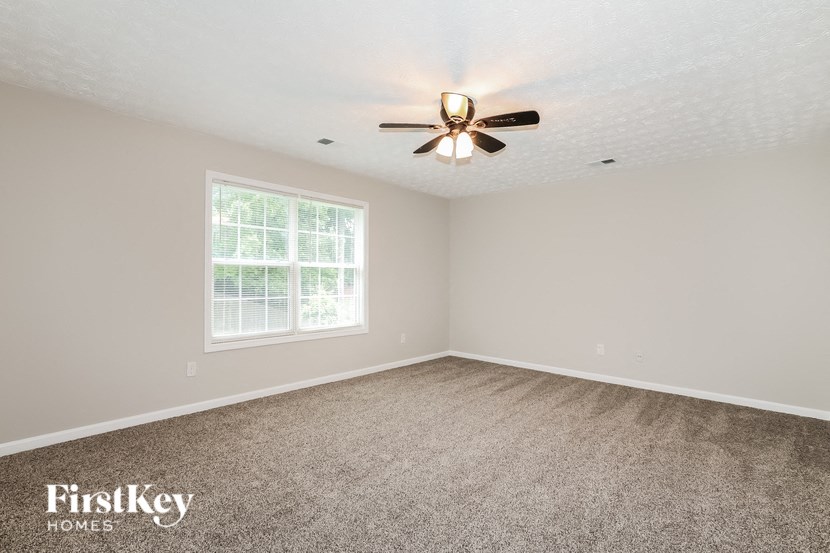 a bedroom with carpet and a ceiling fan