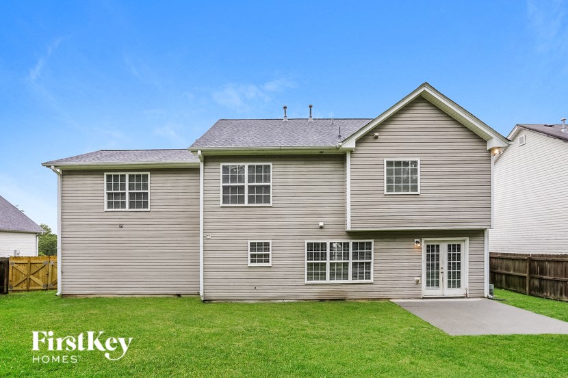 a renovated house with white siding and a green lawn