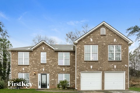 a brick house with white garage doors