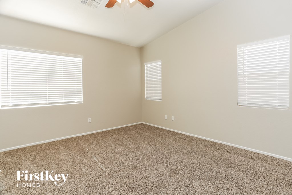 a bedroom with a carpeted floor and two windows