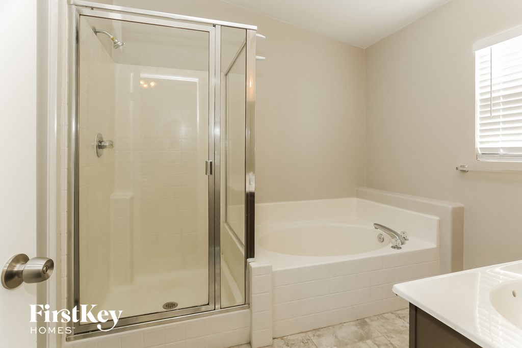 a bathroom with a shower and a tub and a sink