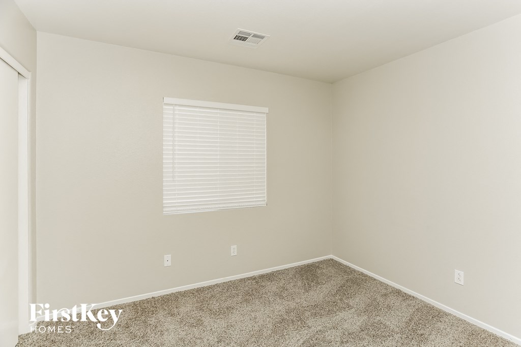 a bedroom with a carpeted floor and a window