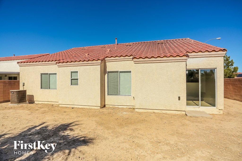 a small house with a red tile roof and green shutters