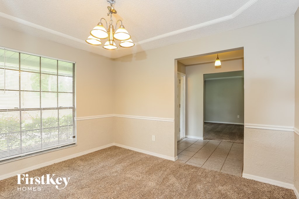 the living room and dining room of a house with a large window