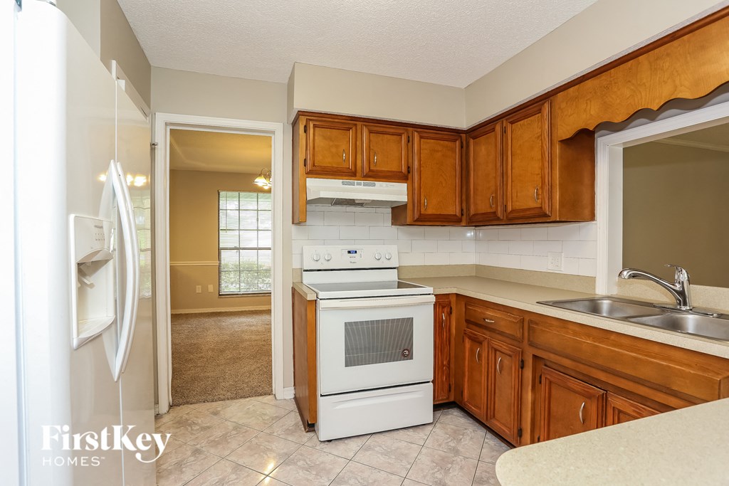 a kitchen with white appliances and wooden cabinets
