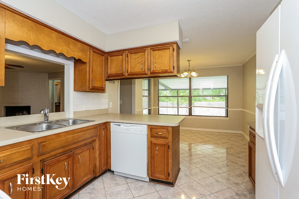 a kitchen with wooden cabinets and a sink and a refrigerator