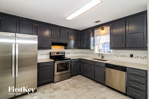 a kitchen with black cabinets and stainless steel appliances