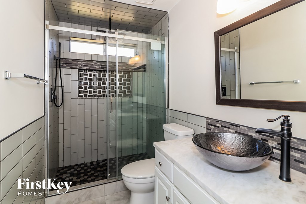 a bathroom with a shower and a sink and a mirror