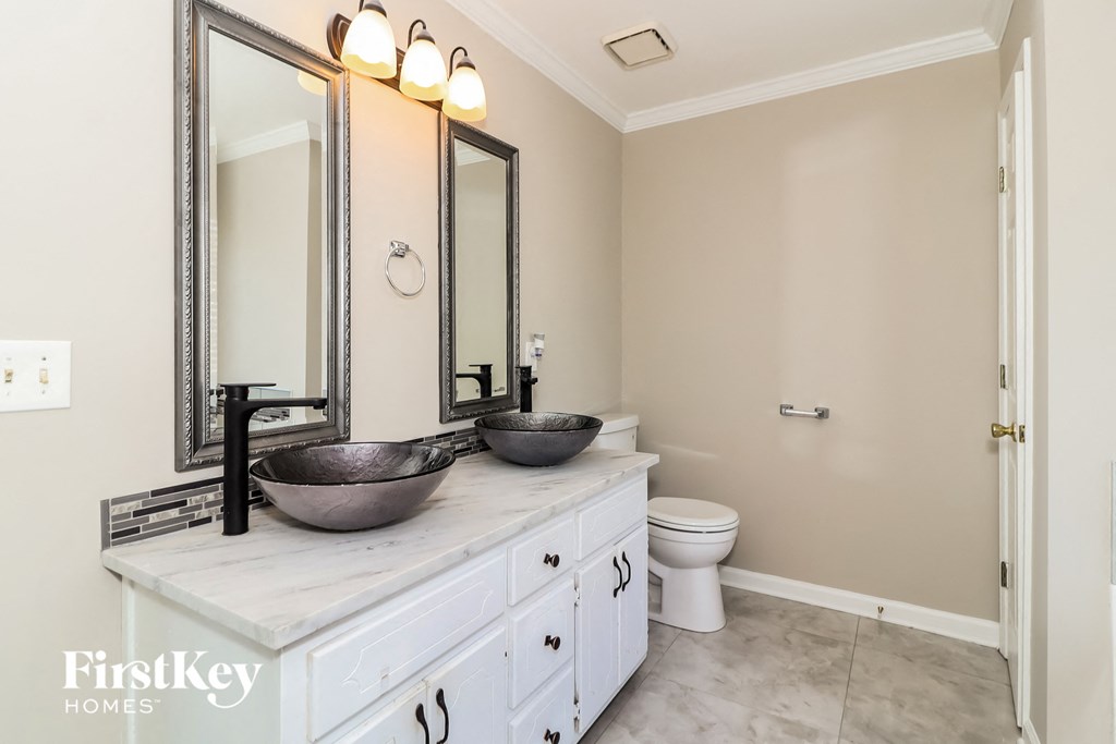 a bathroom with two sinks and two mirrors and a toilet