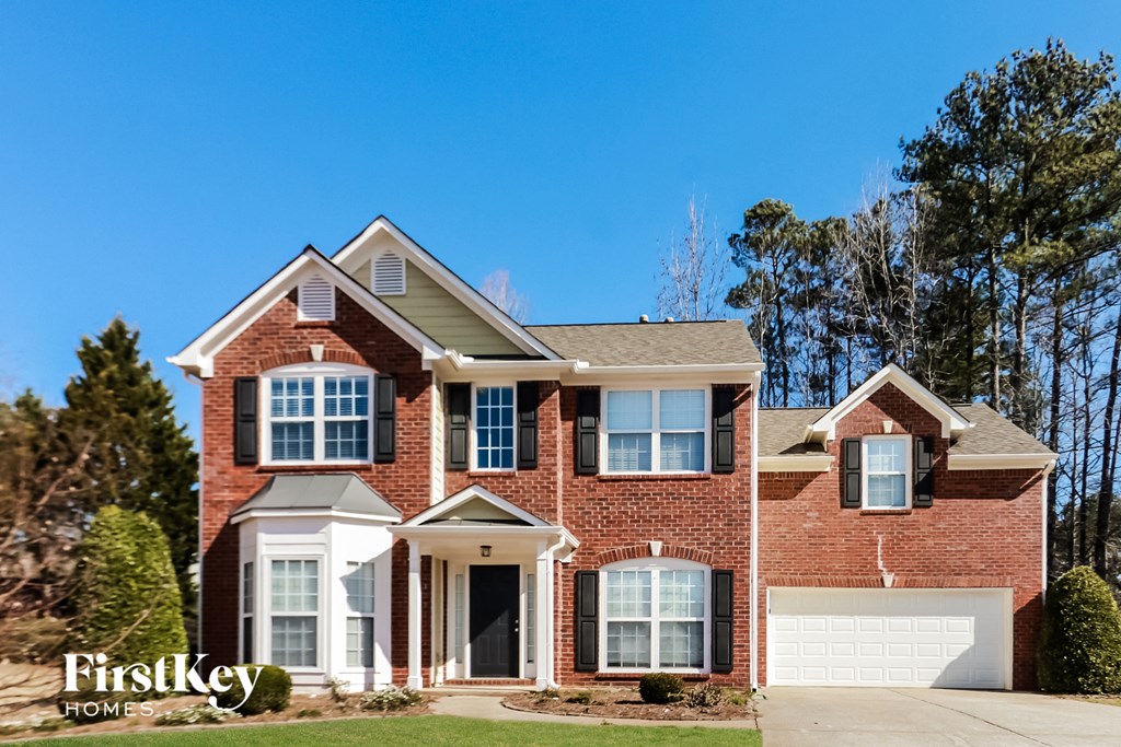 a large brick house with a blue sky in the background
