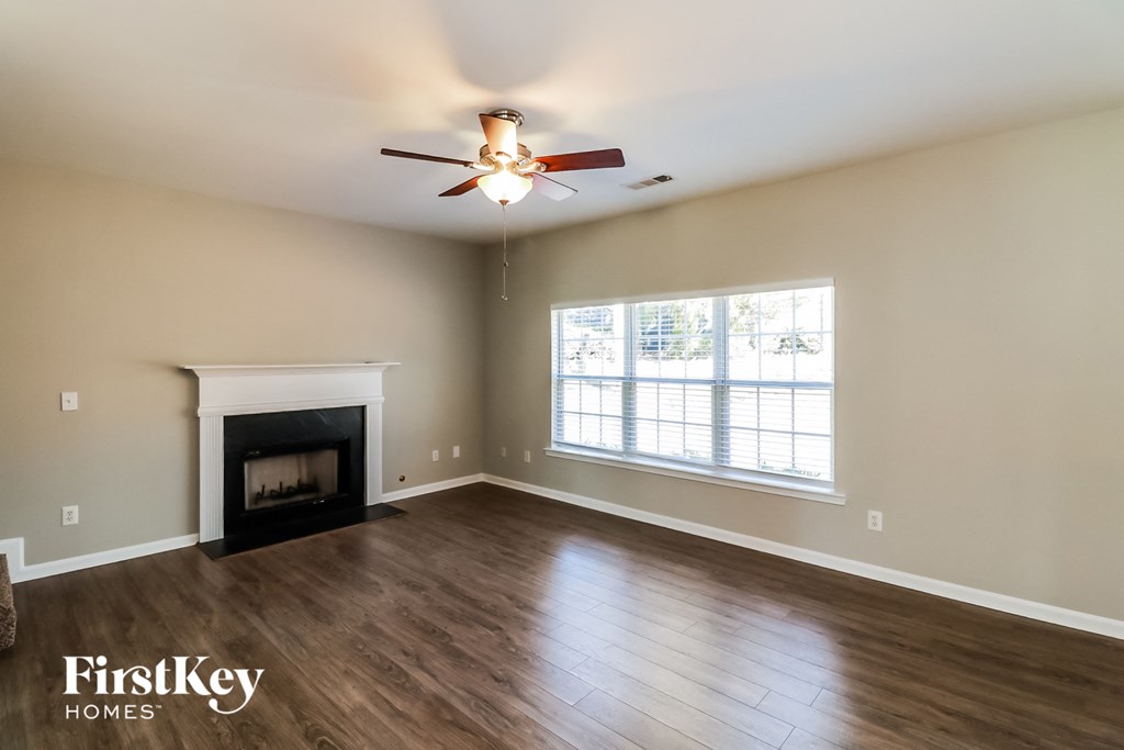 a living room with a fireplace and a ceiling fan