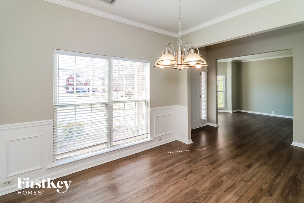 an empty living room with large windows and wood flooring