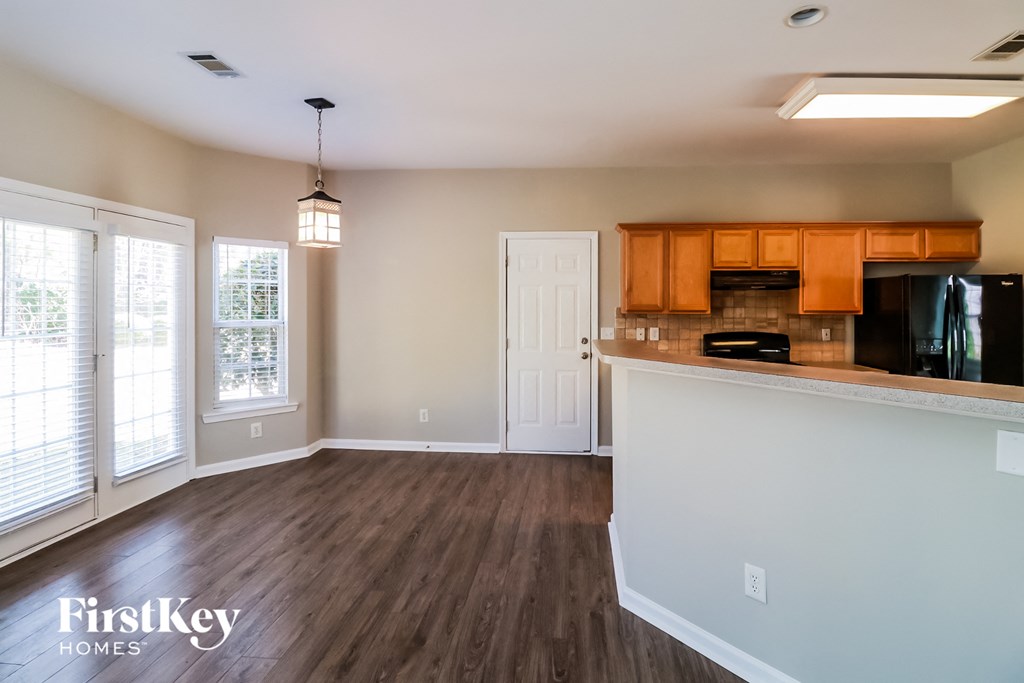 an empty kitchen and living room with wood flooring