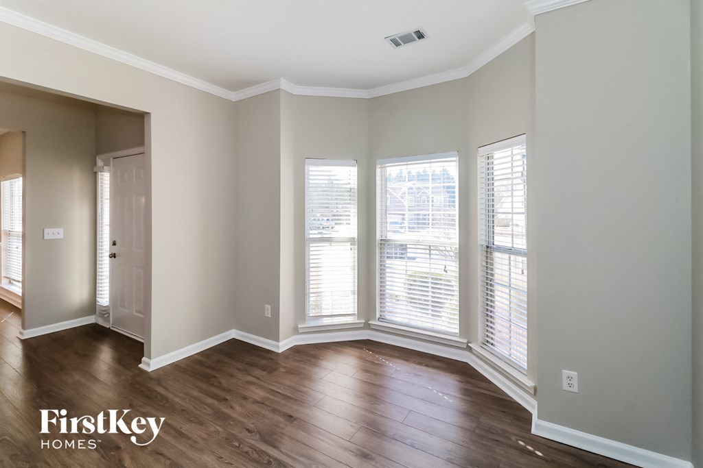 the living room of an empty house with wood floors and windows