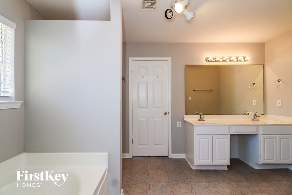 a bathroom with a sink and a tub and a mirror