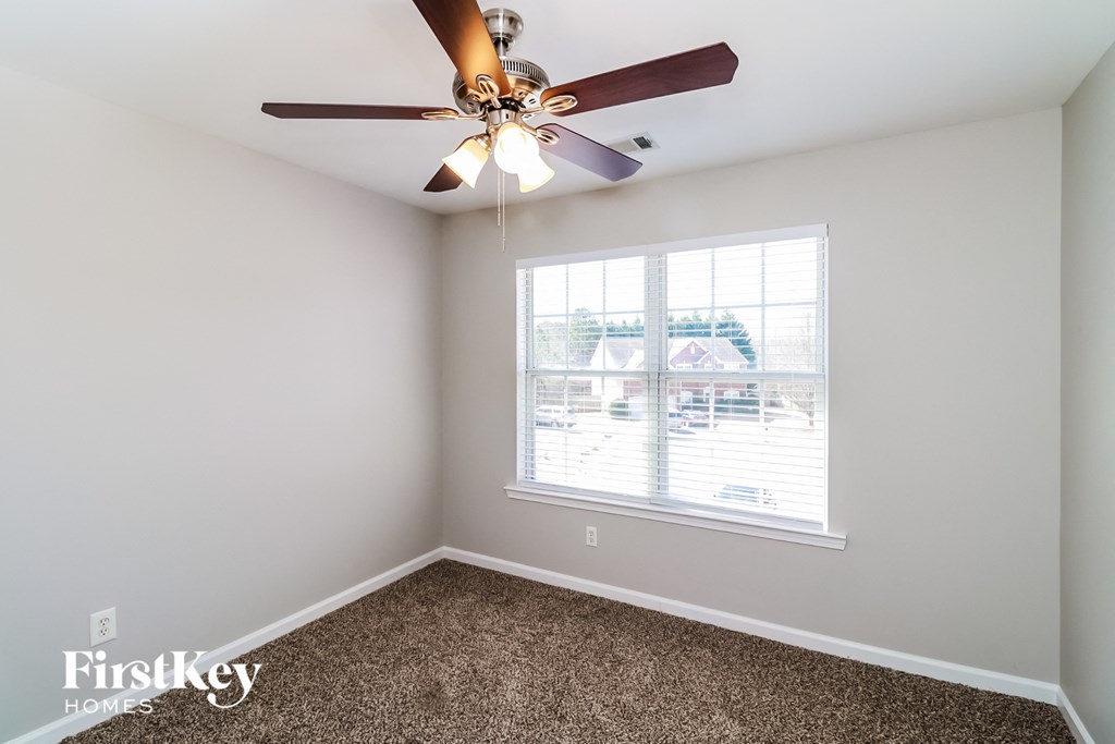 a bedroom with a ceiling fan and a window