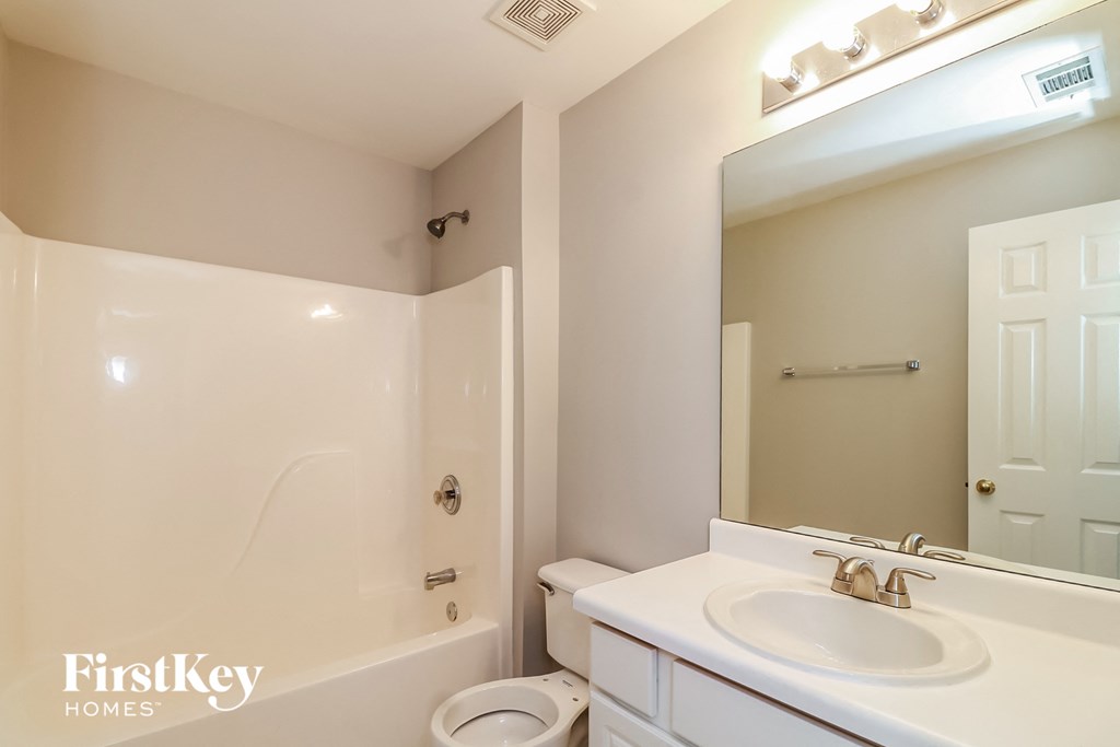 a bathroom with a white sink and a shower and a toilet