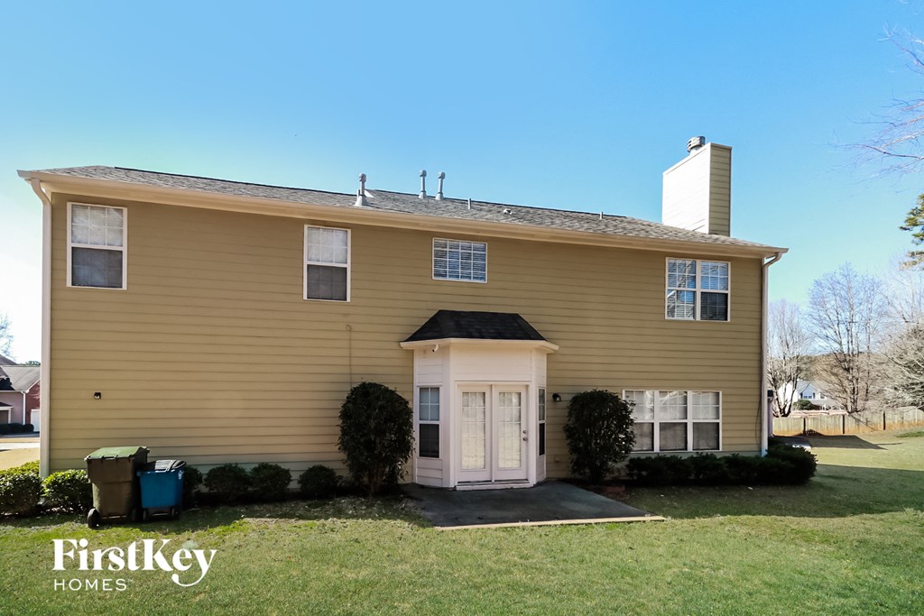 a yellow house with a white front door and a lawn