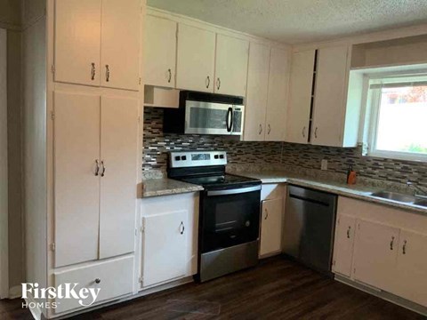 a kitchen with white cabinets and a stove and a microwave