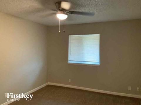 a bedroom with a ceiling fan and a window