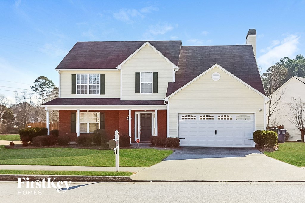 a house with a white garage door in front of a lawn
