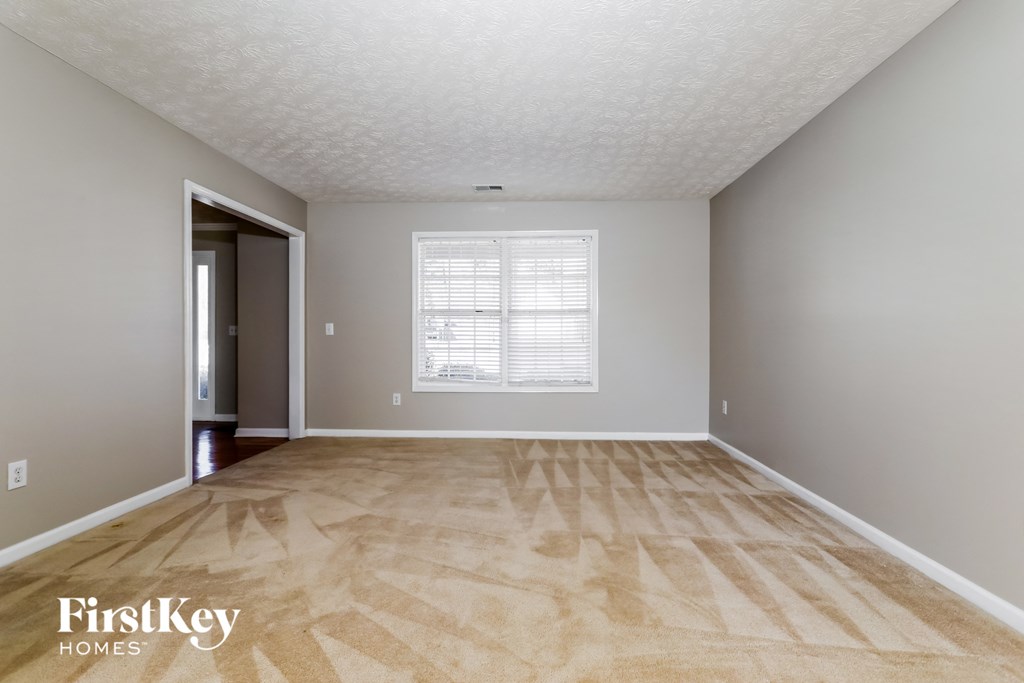 the living room of an empty house with wooden floors and a window