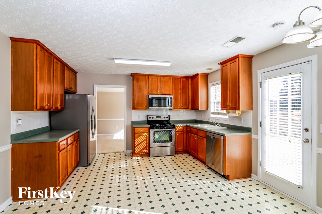 a kitchen with wooden cabinets and a stove and a refrigerator