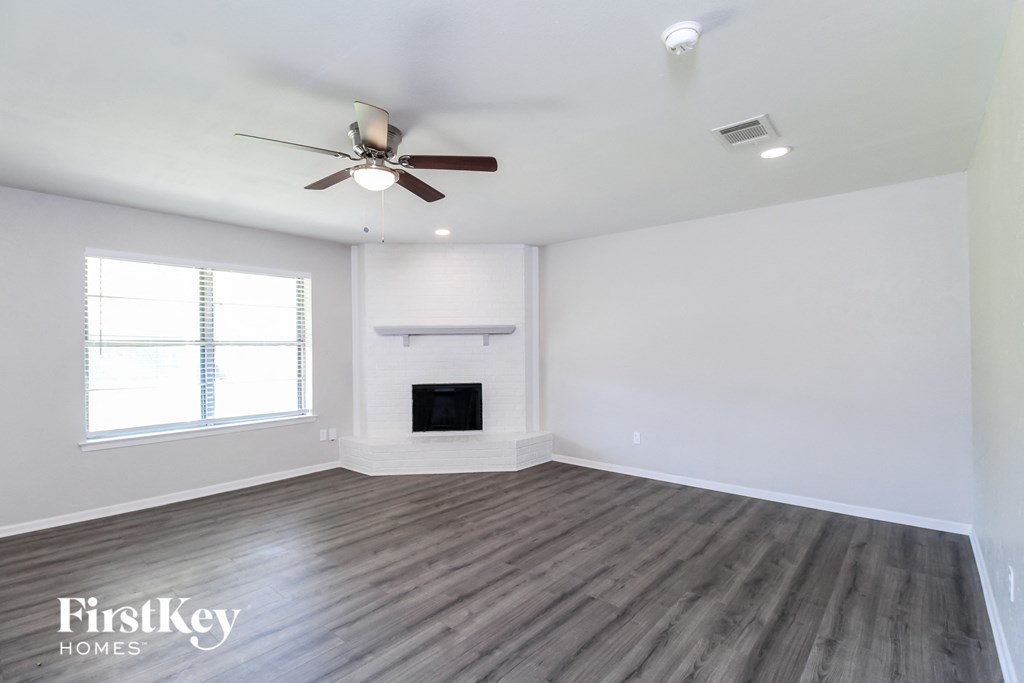a living room with a fireplace and a ceiling fan