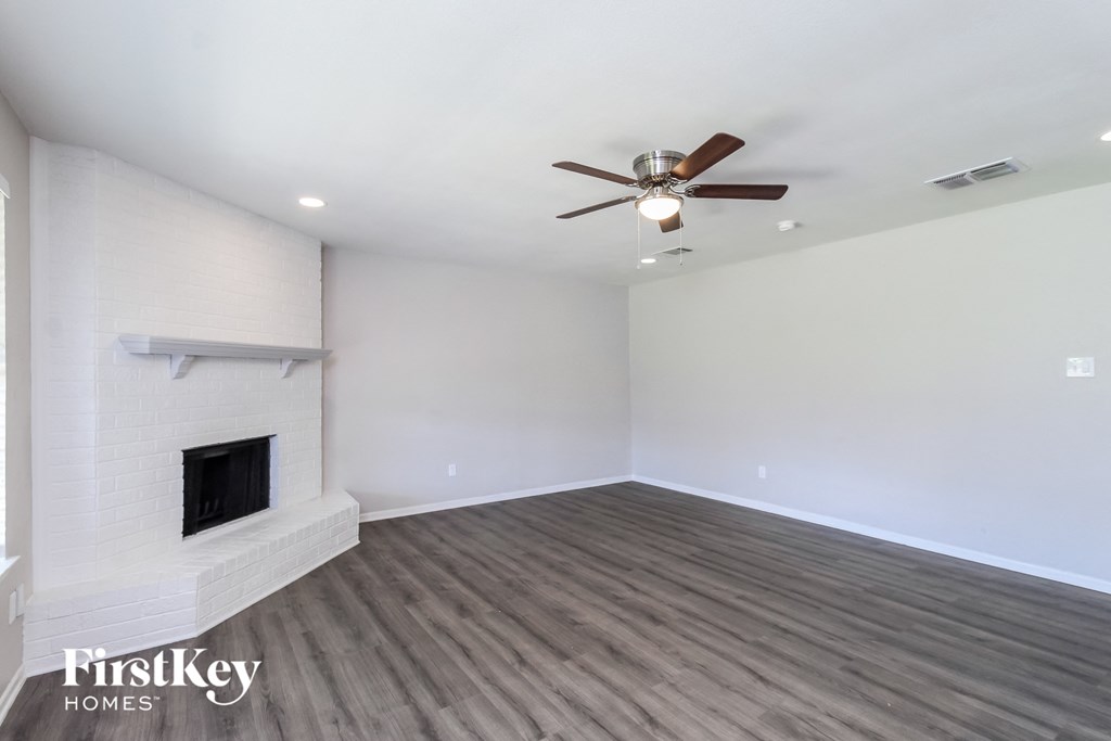 a living room with a fireplace and a ceiling fan