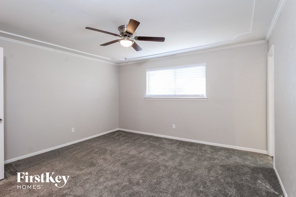a empty room with a ceiling fan and a window