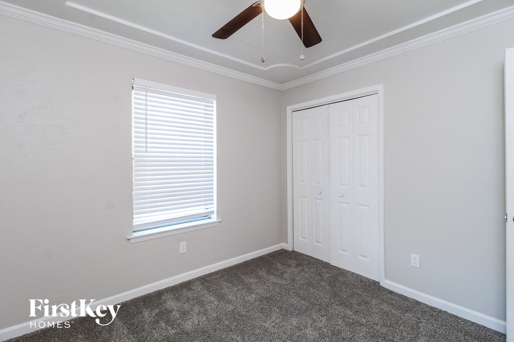 a bedroom with a ceiling fan and a white door